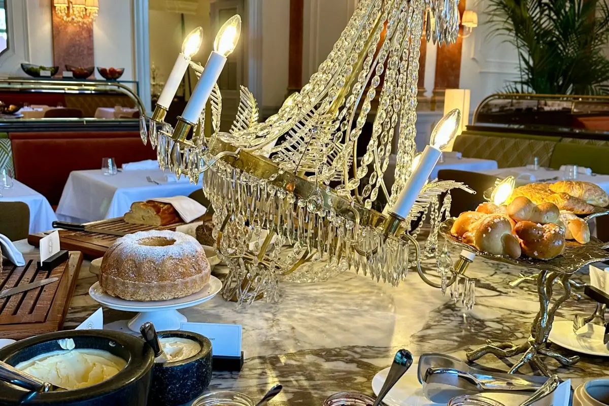 Große Momente mit kulinarischer Finesse Ein Kronleuchter auf einem Tisch, kunstvoll drapiert und mit Gebäck drumherum.