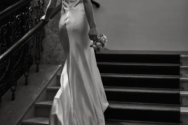 Eine Frau in einem weißen Kleid hält einen Blumenstrauß.