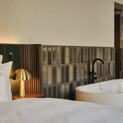 Interieur ist eine Lebenseinstellung Ein Anschnitt eines Bettes sowie einer freistehenden Badewanne