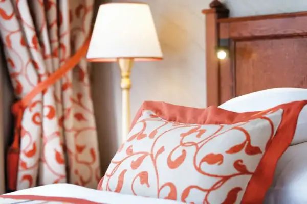 Kissen Ein Bett mit einer Lampe und einem Kissen.