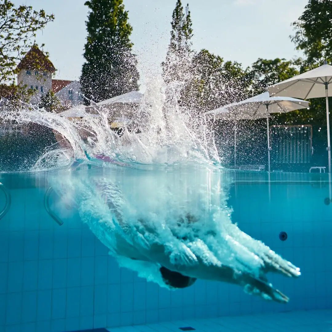 Beheizte Poollandschaft im A-ROSA Ostseehotel Kühlungsborn Sprung ins Wasser der beheizten Poollandschaft im A-ROSA Ostseehotel Kühlungsborn mit Blick auf die Ostseehimmel