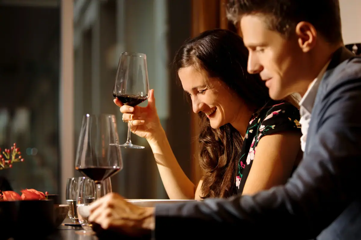 Ein Mann und eine Frau halten Weingläser.