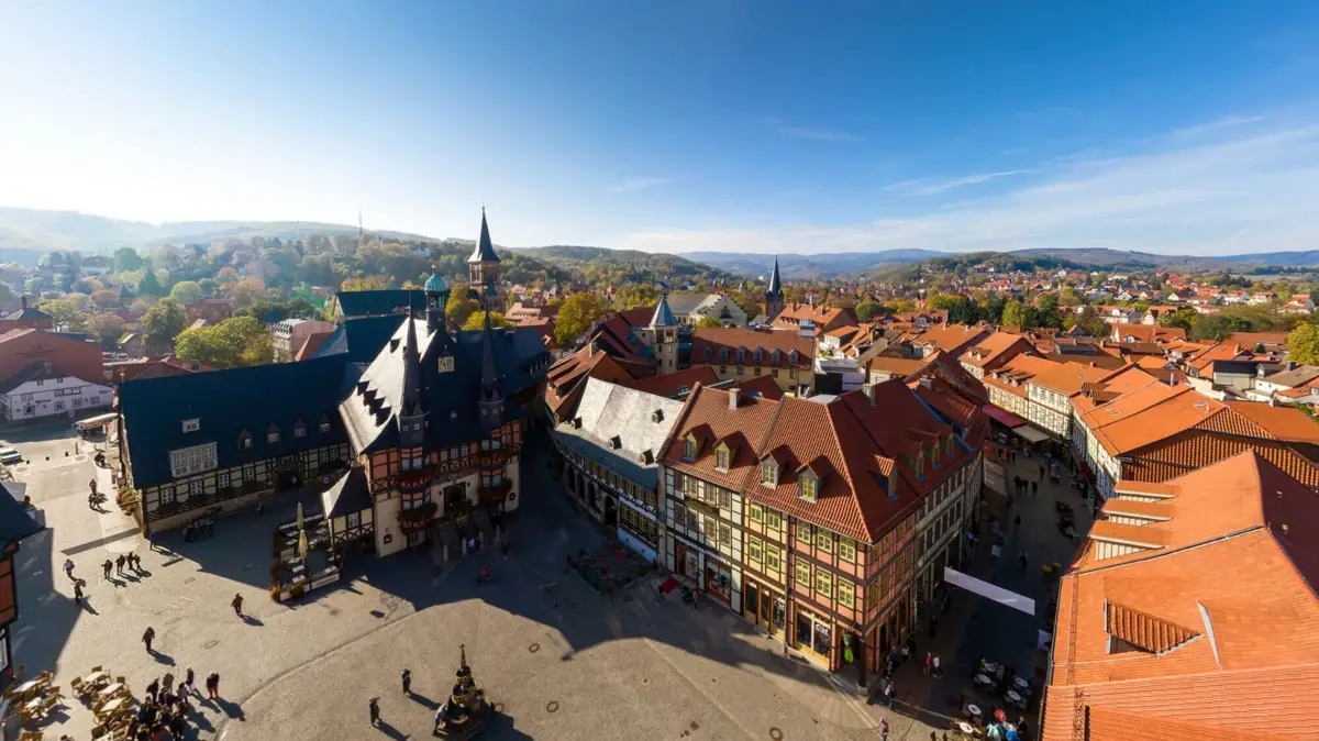 Eine Stadt im Harz mit Gebäuden und Bäumen unter einem Himmel mit Wolken.