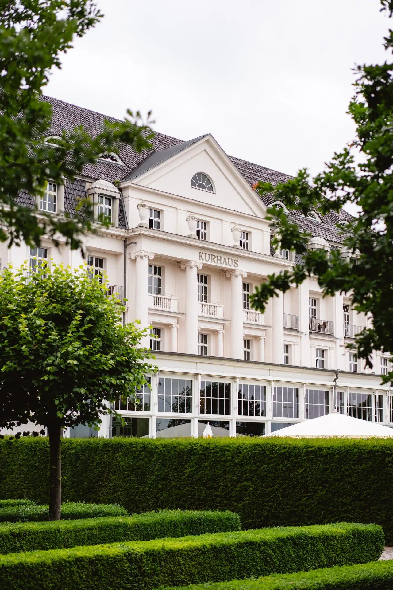 A-ROSA Travemünde Weißes Gebäude mit Bäumen im Hintergrund