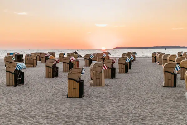 Strandkörbe Eine Gruppe von Stühlen am Strand.