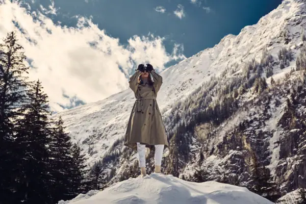 Winter in Bad Gastein Eine Frau steht auf einem verschneiten Berg mit einem Fernglas.