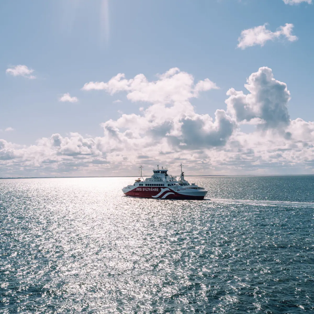 Syltfähre Ein Boot auf dem Wasser unter einem bewölkten Himmel.