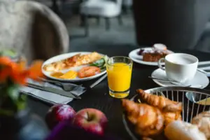 Frühstück Ein Teller mit Frühstück und ein Glas Saft auf einem Tisch.