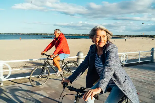 Ein Mann und eine Frau fahren Fahrrad am Strand.