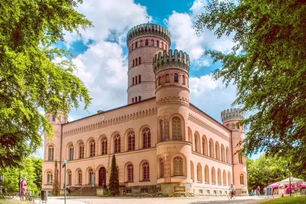 Großes Gebäude mit Turm vor bewölktem Himmel.