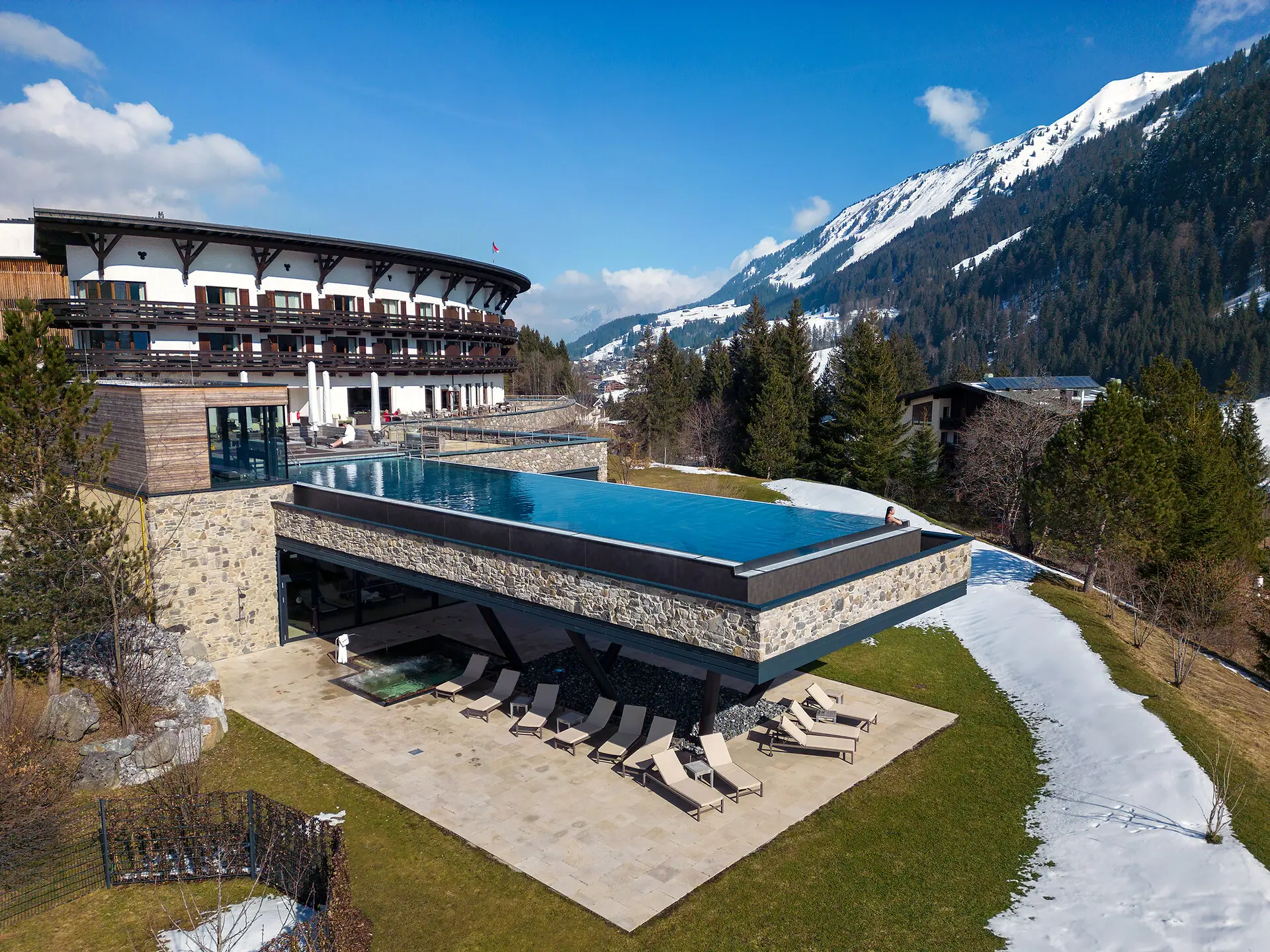 A-ROSA Ifen Hotel Kleinwalsertal Ein Schwimmbecken in einem Gebäude mit einem Berg im Hintergrund.