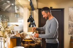 Frühstück Buffet Ein Mann steht in einer Küche.