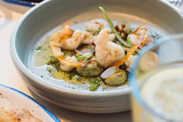 Gericht im A-ROSA Gardasee Eine Schüssel mit Garnelen auf einem Tisch.