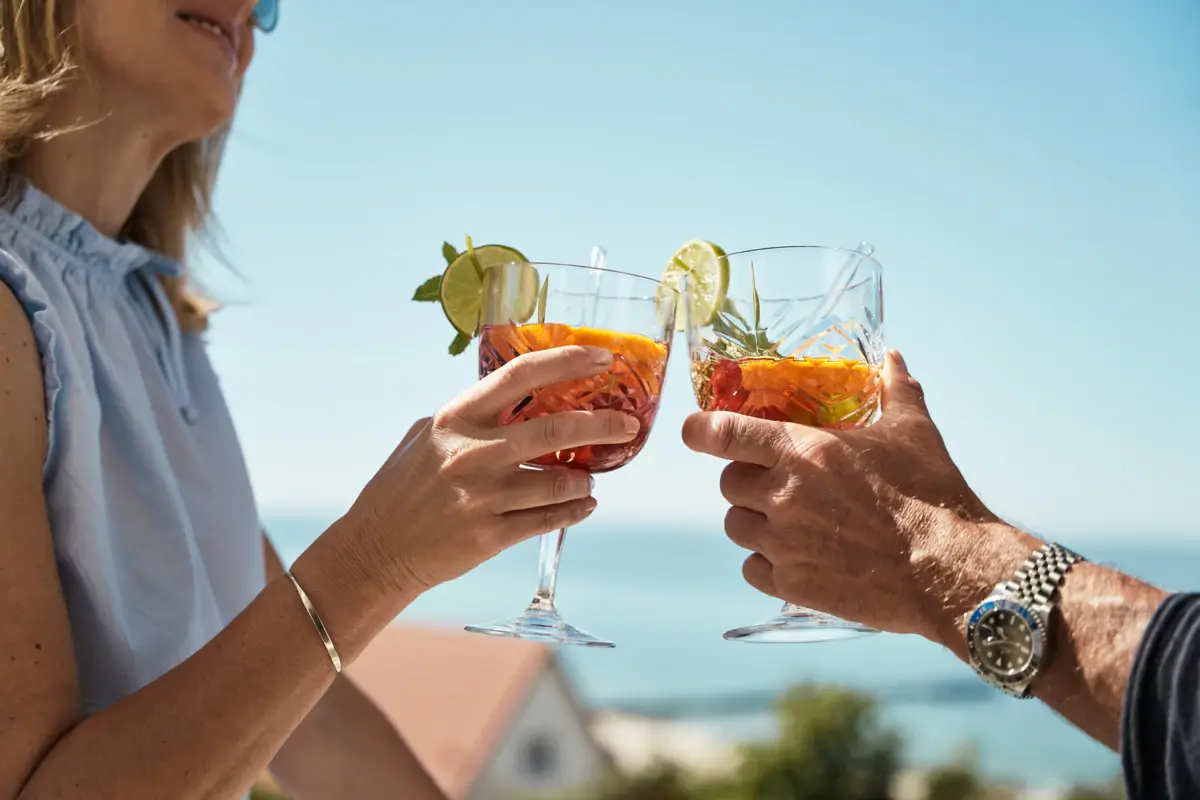 Hände eines Paares, das Gläser mit Getränken hält