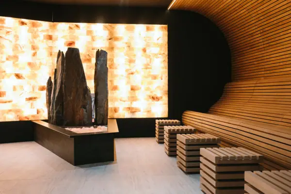 Ein Raum mit einer großen Felskulptur und Bänken.