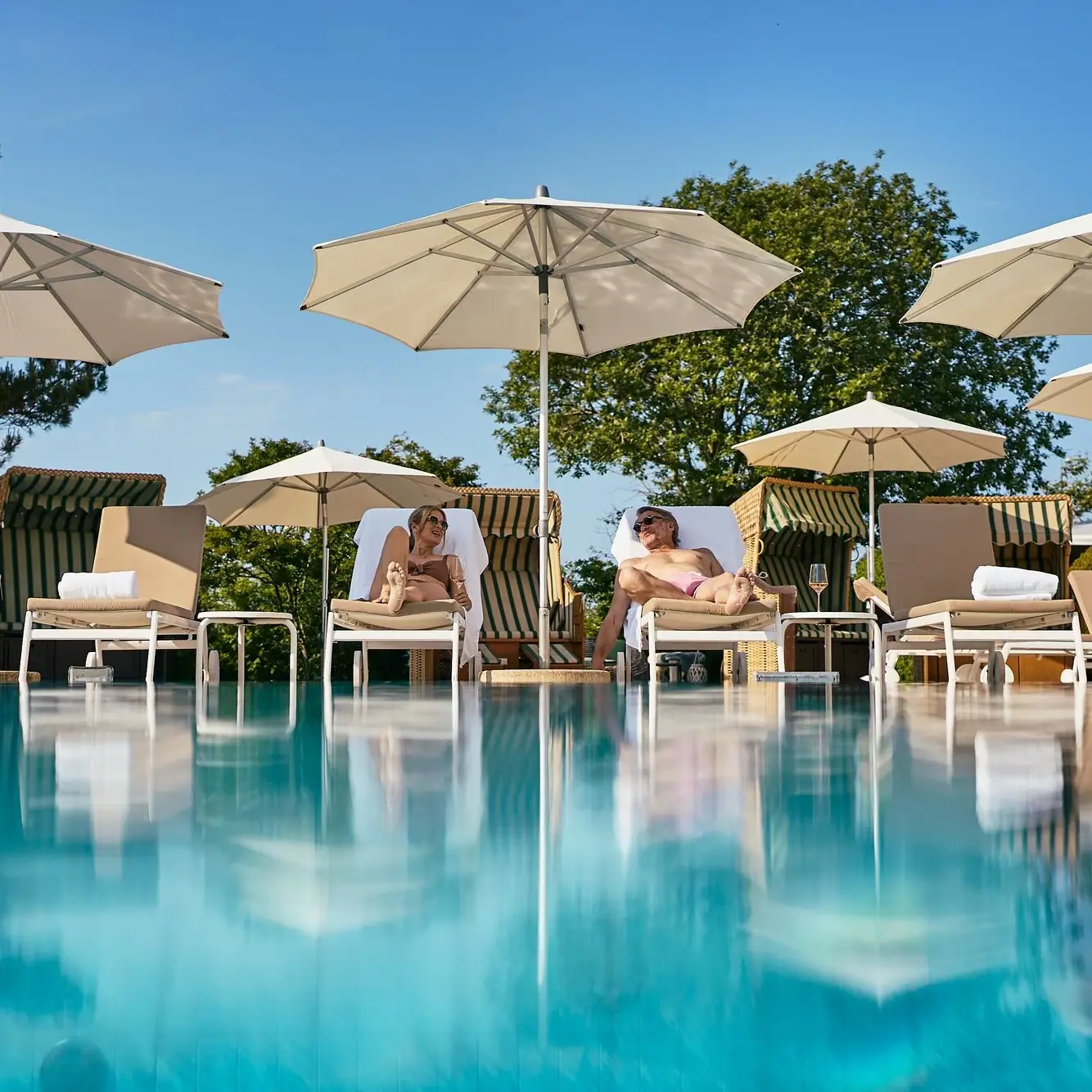 A-ROSA Ostseehotel Kühlungsborn Eine Gruppe von Menschen sitzt auf Stühlen am Pool.