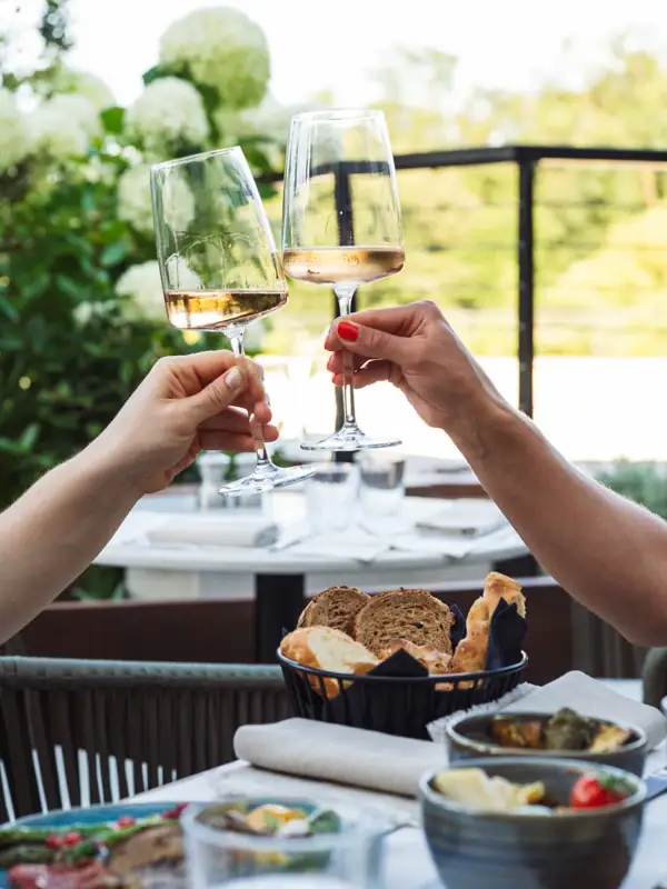 Zwei Hände halten Weingläser.