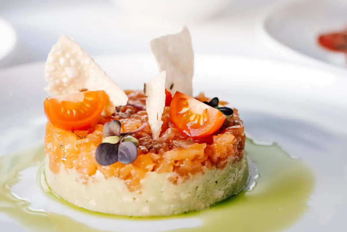Ein Teller mit kunstvoll angerichteter Speise auf einem Tisch.