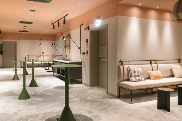 Foyer im A-ROSA Gardasee Ein Raum mit einer Couch und Tischen. Es gibt verschiedene Stehtische, die sich für einen Empfang eignen.