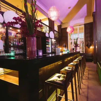 Bar Travemünde Eine Bar mit Hockern und einer Reihe von Stühlen.