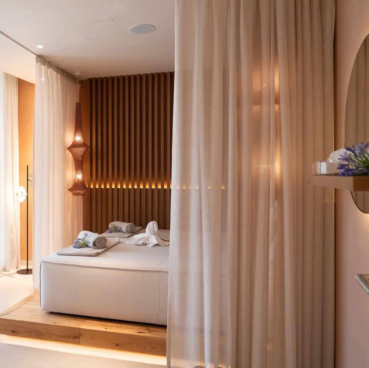 Ein Day-Bed mit weißen Laken und darauf liegenden Handtüchern.