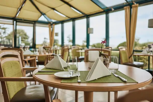 Restaurant „Kiek in“ mit Ostseeblick Gedeckter Tisch im Restaurant „Kiek in“ mit Blick ins Grüne