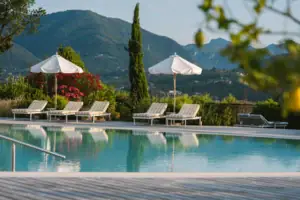 Außenpoolbereich Ein Außenpool mit Liegestühlen und Sonnenschirmen.