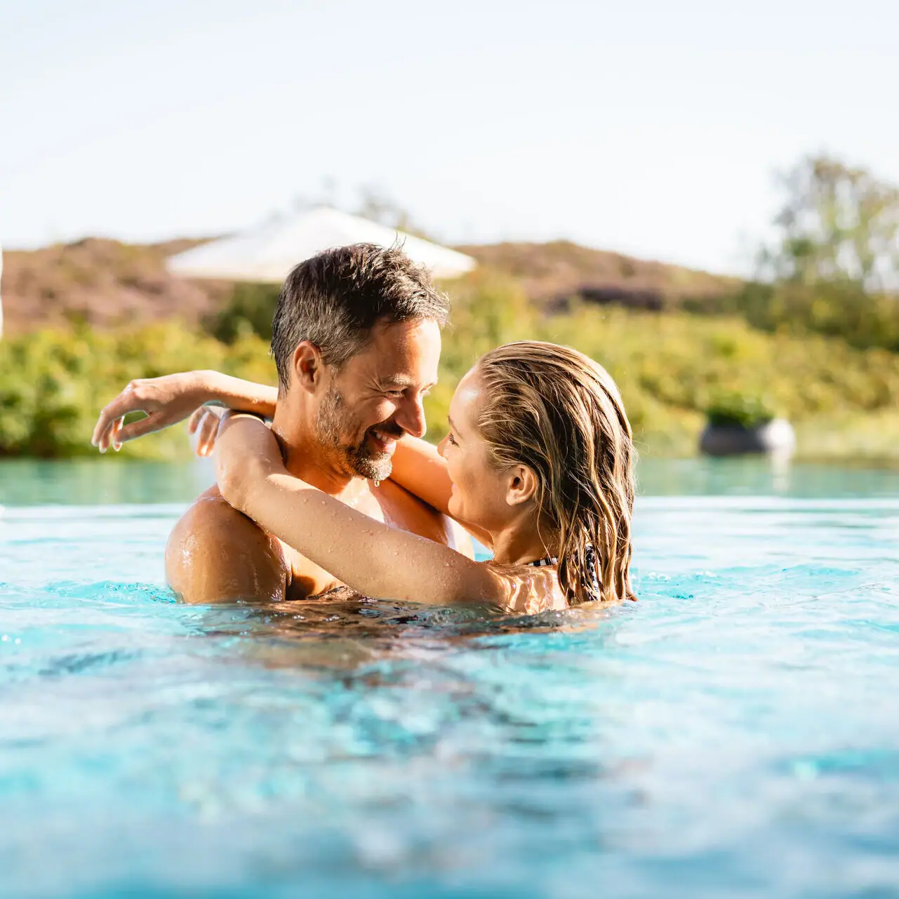 Ein Mann und eine Frau in einem Pool im Freien.