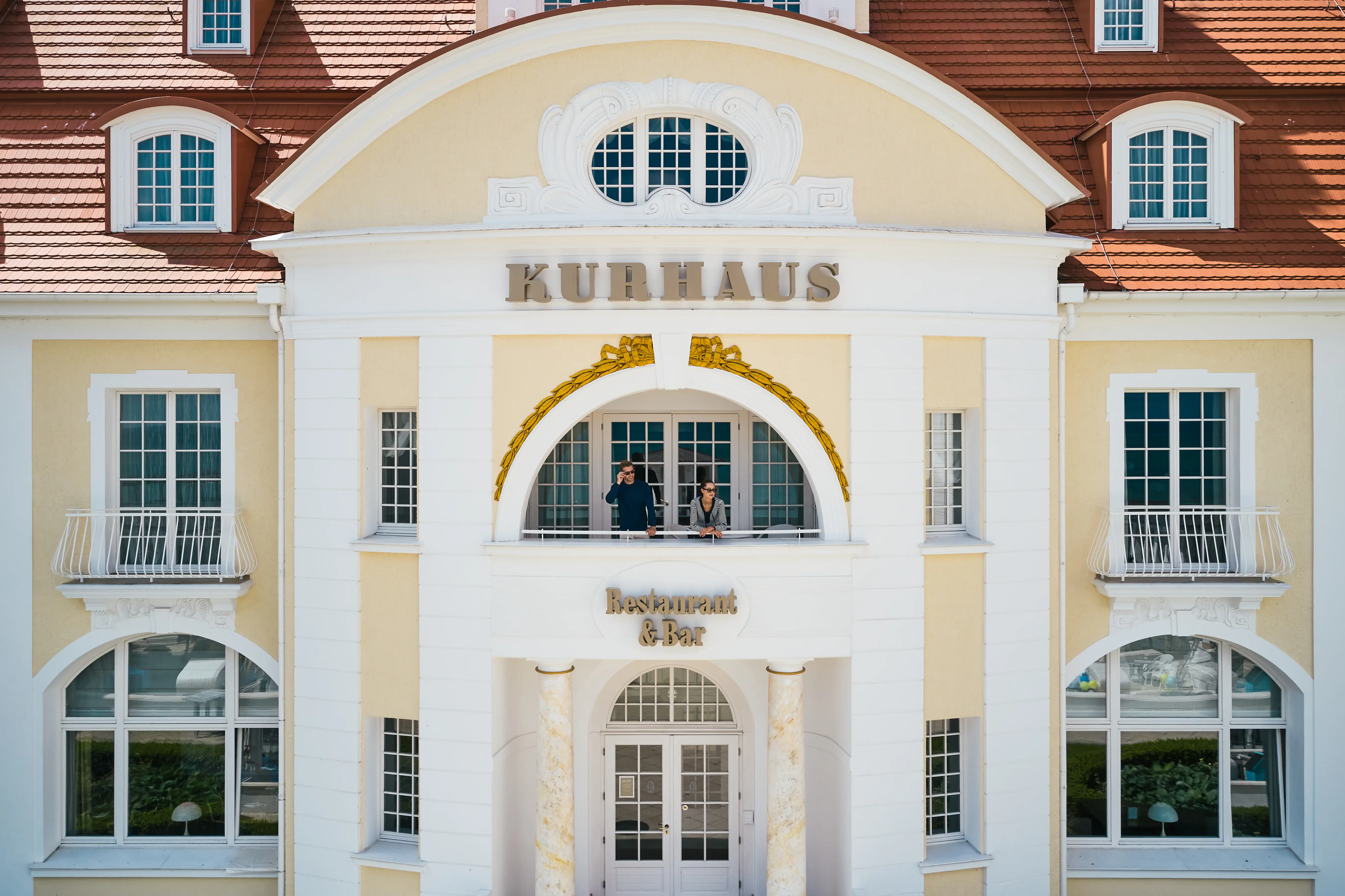 Ein Gebäude mit einem Paar, das auf dem Balkon steht.