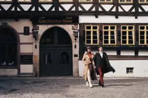 A-ROSA Gothisches Haus Ein Mann und eine Frau gehen vor einem Gebäude.