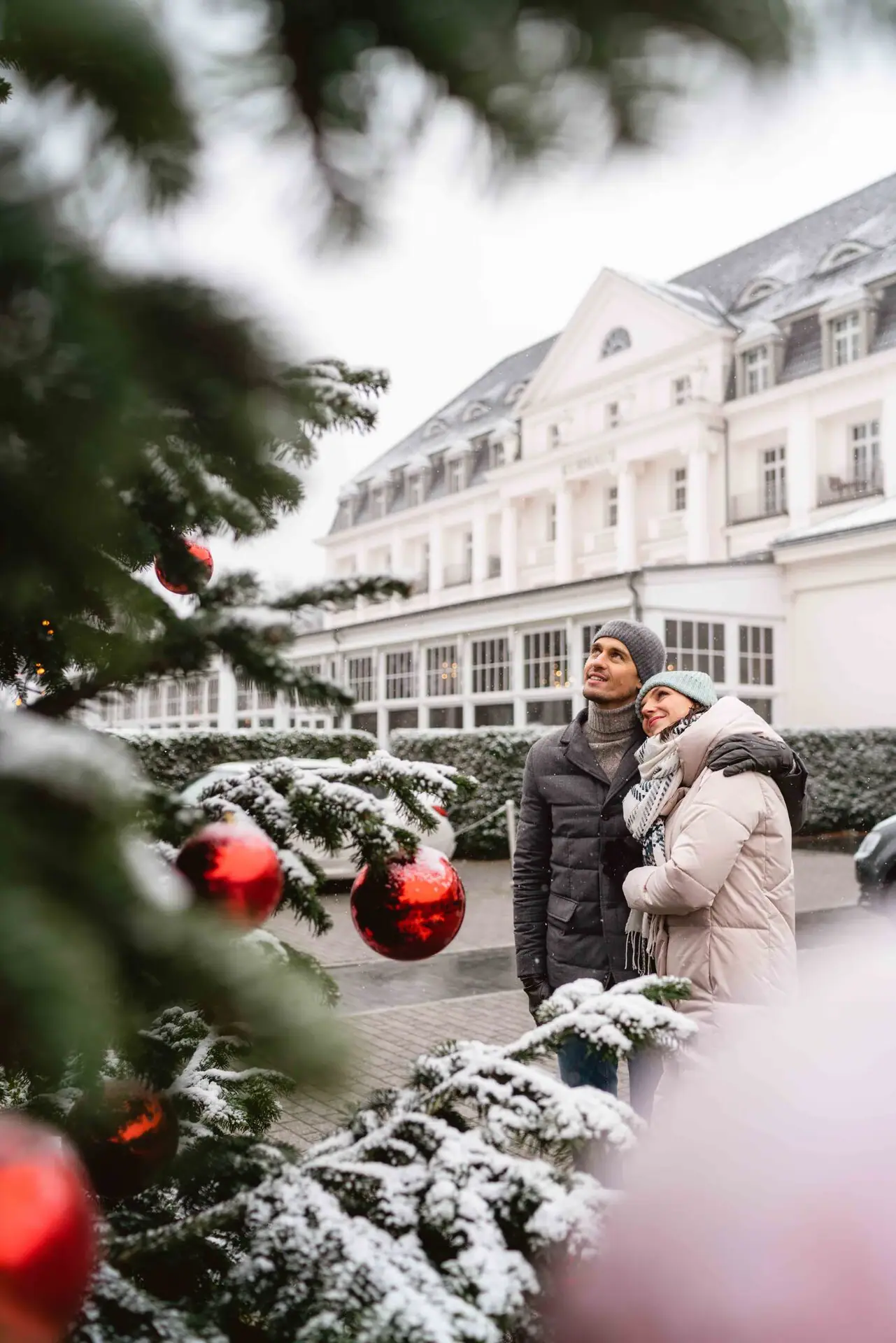 A-ROSA Travemünde Ein Mann und eine Frau stehen vor einem Weihnachtsbaum.