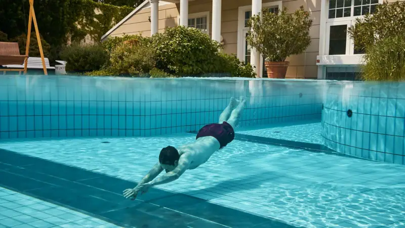 Ein Mann schwimmt in einem Pool.