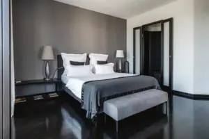 Zimmer Ein Bett mit einer Bank und Lampen in einem Zimmer.