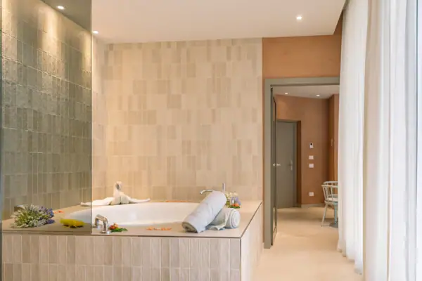 Badewanne mit aufgerollten Handtüchern in einem Badezimmer