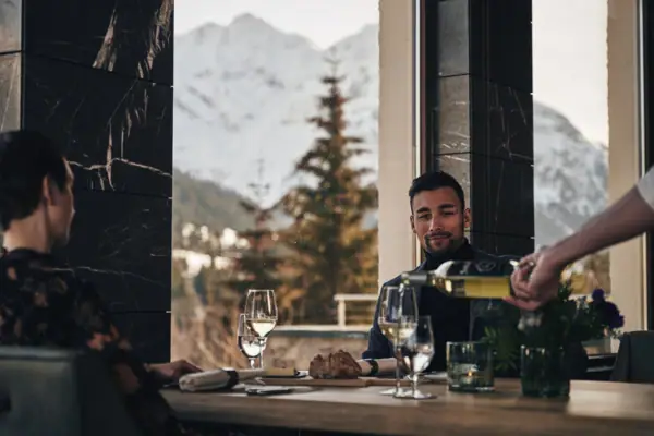 Ein Mann schenkt Wein in ein Glas ein.