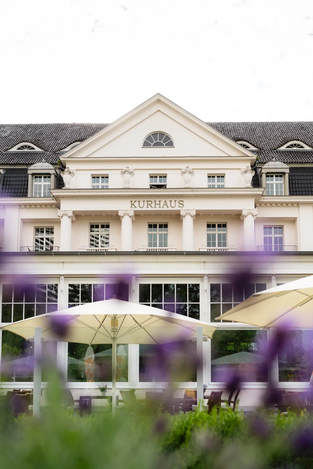 A-ROSA Travemünde Ein Gebäude mit einem großen Fenster und einem großen Sonnenschirm.