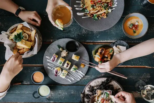 Tisch mit Essen Eine Gruppe von Menschen isst gemeinsam.