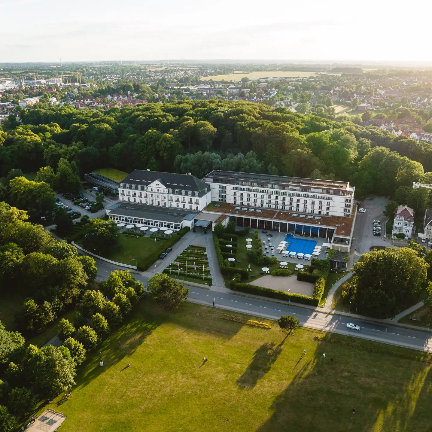 Großes Gebäude mit Pool und umgebenden Bäumen.