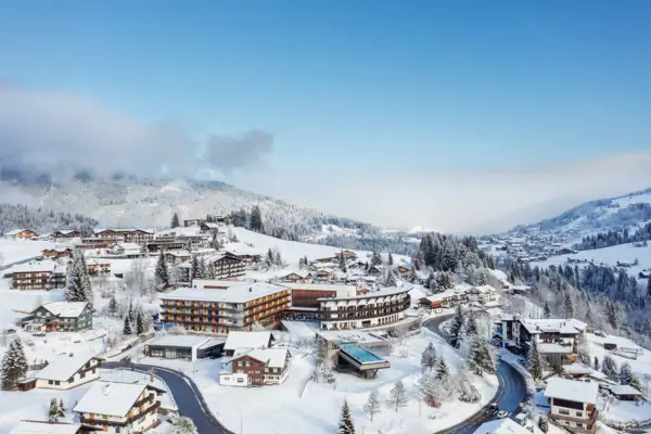 A-ROSA Ifen Hotel Kleinwalsertal Verschneite Landschaft mit Gebäuden und Bäumen.