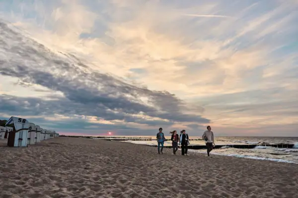 Eine Gruppe von Menschen spaziert am Strand.