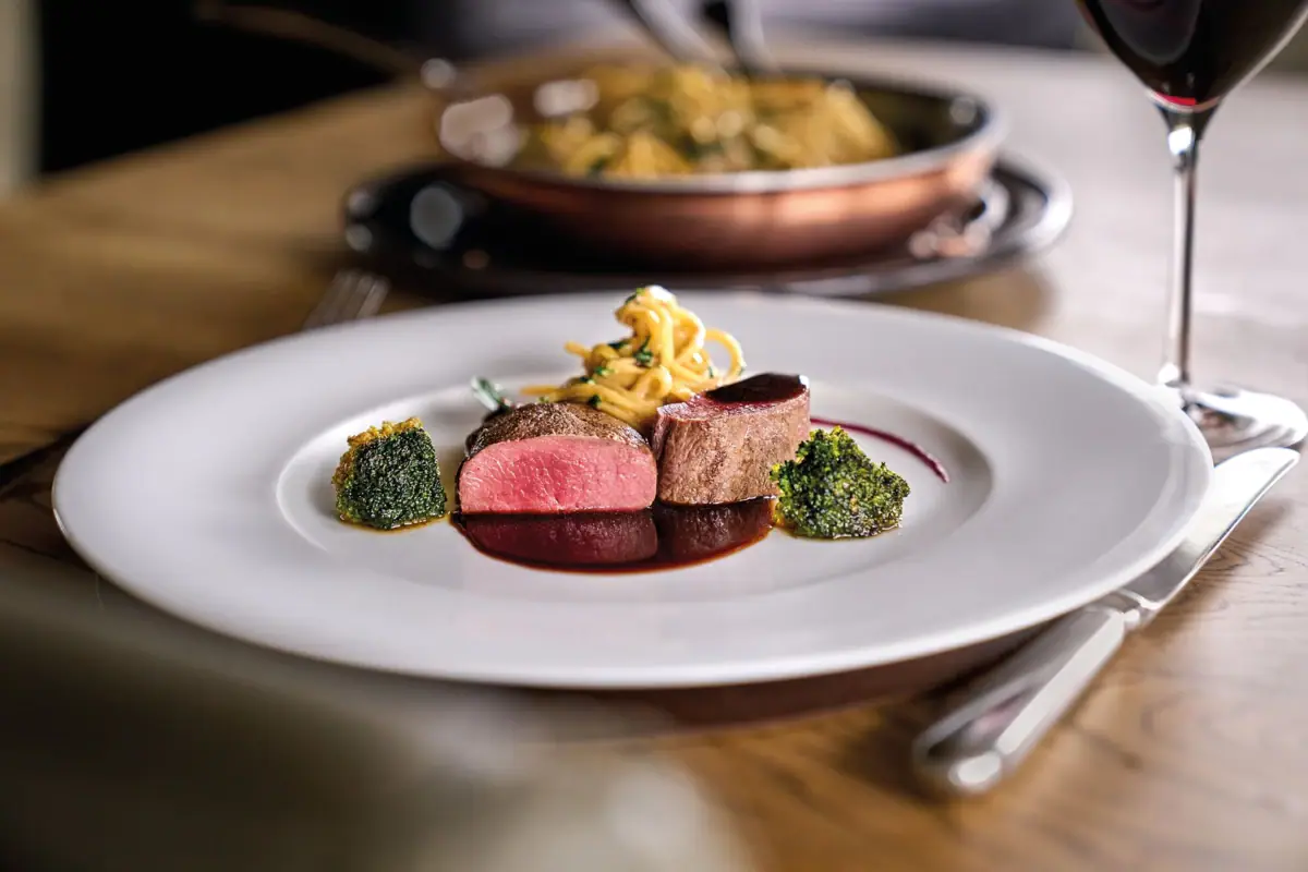 Ein leckeres Menü Ein Teller mit kunstvoll angerichteten Speisen auf einem Tisch.