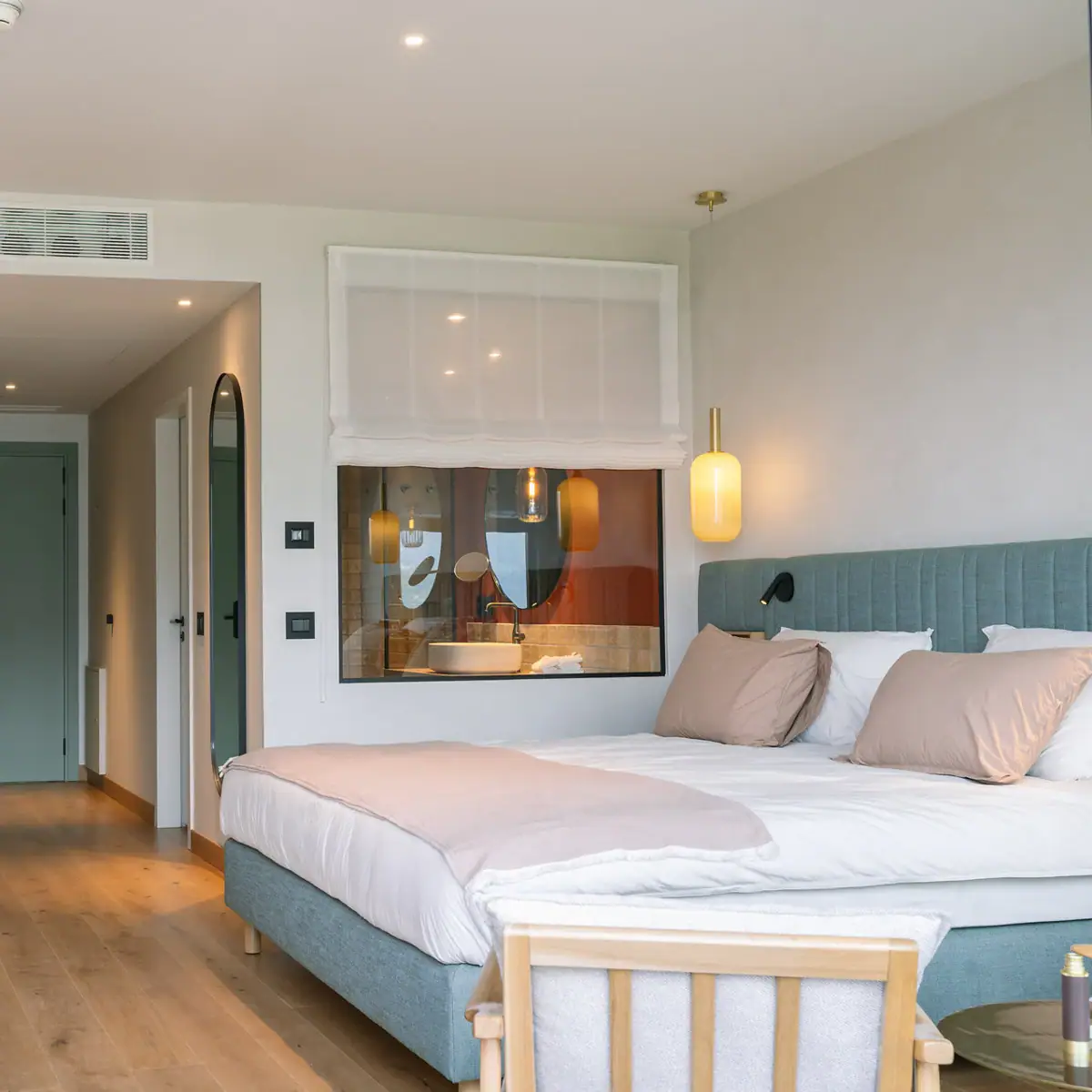 Zimmer im A-ROSA Gardasee Schlafzimmer mit Bett und Fenster ins Badezimmer.