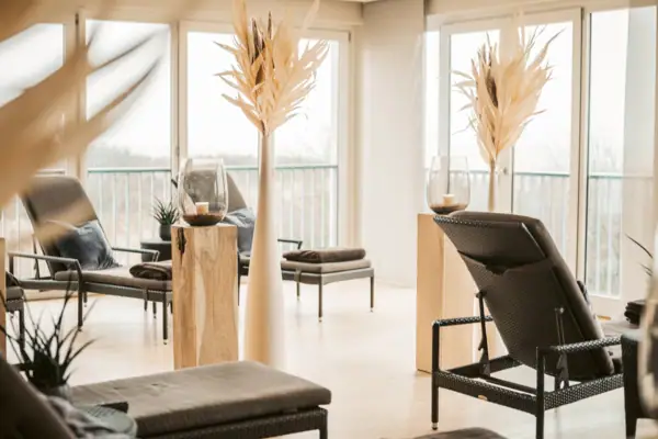 Ein Zimmer mit Stühlen und einem Tisch mit Kerzen.