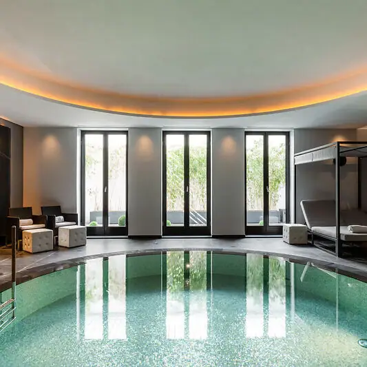 Innenpool mit Liegestuhl und Stühlen.