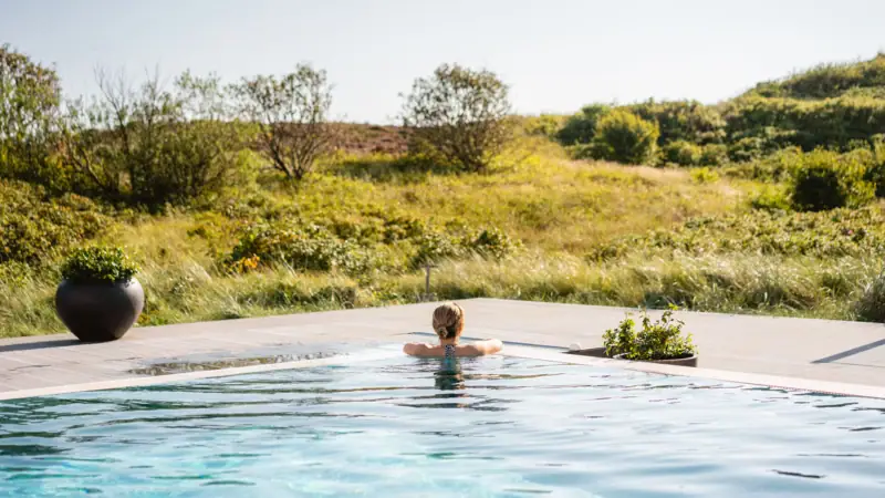 Wellness auf Sylt Eine Frau schwimmt in einem Pool im Freien.