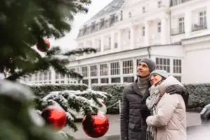 A-ROSA Travemünde Ein Mann und eine Frau stehen vor einem Weihnachtsbaum.