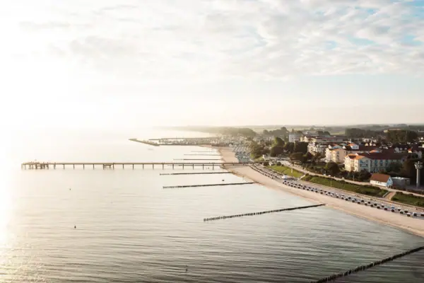 Luftbild Strand Ostseehotel Eine lange Brücke über ein Gewässer.