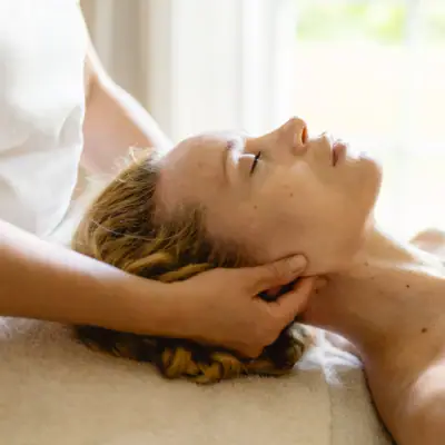 SPA Anwendung Eine Frau liegt entspannt auf einem Massagetisch.