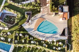 Außenpoolbereich von oben Ein Swimmingpool, umgeben von Gras und Rasenflächen.