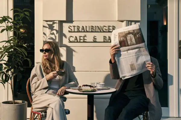 Café & Bar Ein Mann und eine Frau sitzen an einem Tisch und lesen eine Zeitung.